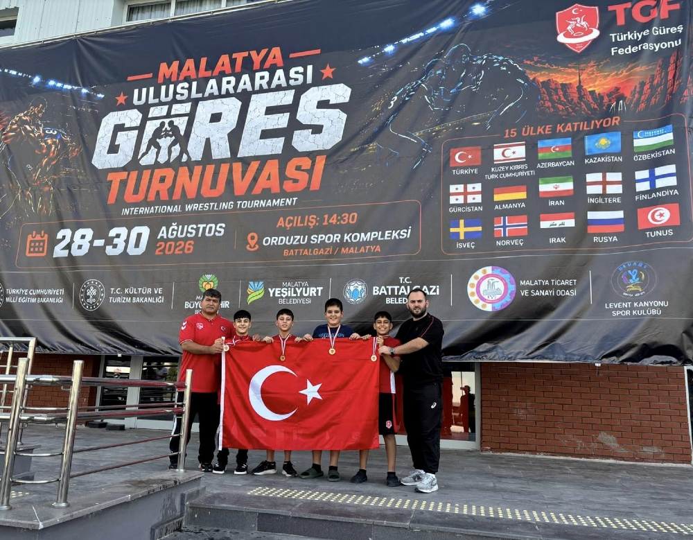 Malatya Uluslararası Güreş Turnuvası afişinin önünde, boyunlarında madalyalarla Türk bayrağını tutan dört genç sporcu ve onlara eşlik eden iki antrenör yer alıyor. Arka plandaki büyük afişte 28-30 Ağustos 2026 tarihleri,  Spor Kompleksi bilgisi ve turnuvaya katılan 15 ülkenin bayrakları ile Türkiye Güreş Federasyonu logosu bulunuyor.